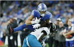  ?? DUANE BURLESON — THE ASSOCIATED PRESS ?? Jacksonvil­le Jaguars safety Rayshawn Jenkins pushes Detroit Lions tight end Shane Zylstra out of bounds during the second half of last Sunday’s game in Detroit.