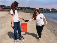  ??  ?? Shelby O’Neil, right, and a friend help clean up a beach in California.