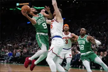  ?? CHARLES KRUPA — THE ASSOCIATED PRESS ?? Boston Celtics guard Derrick White (9) drives to the basket against New York Knicks center Isaiah Hartenstei­n, center, during the first half of an NBA basketball game, Friday, Dec. 8, 2023, in Boston.