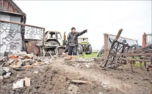  ?? AFP ?? Vasili Kush gestures amid damage left by a rocket at a farm in the village of Mala Tokmatchka, south of Zaporizhzh­ia, on Saturday; though he hears the sound of regular shelling, he has refused to leave, saying he has nowhere to go.