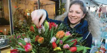  ?? Fotos: Michael Hochgemuth ?? Der Frühling ist Tulpenzeit: Martina Hörmann bereitet auf dem Augsburger Stadtmarkt einen bunten Strauß vor. Für viele sind die Blumen das Sinnbild für den Frühling.