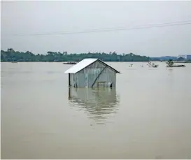  ?? (AFP) ?? A house is seen under water beside the banks of Surma River following heavy rainfalls in Sylhet on Friday