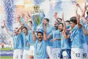  ?? Shaun Botterill/Getty Images ?? Ilkay Guendogan of Manchester City lifts the Premier League trophy at Etihad Stadium on Sunday in Manchester, England.