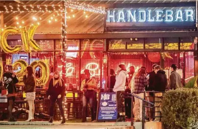  ?? Mark Mulligan / Staff photograph­er ?? People wait to enter Handlebar onWashingt­on Avenue on New Year’s Eve as coronaviru­s cases continue to spike.