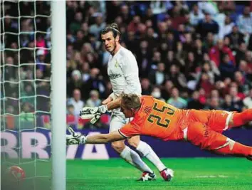  ?? AFP ?? Net gains Real Madrid’s Gareth Bale scores past Rayo Vallecano goalkeeper Yoel during their Spanish La Liga match at the Santiago Bernabeu stadium in Madrid on Sunday.