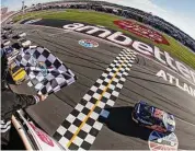  ?? Sean Gardner/Getty Images ?? Joey Logano takes the checkered flag to win the NASCAR Cup Series Ambetter Health 400 at Atlanta Motor Speedway on Sunday.
