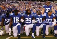  ?? MICHAEL REAVES/GETTY IMAGES ?? Members of the Indianapol­is Colts kneel for the national anthem before a game in the same vein as Colin Kaepernick.