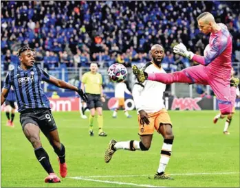  ?? AFP ?? Valencia’s Spanish goalkeeper Jaume Domenech jumps to deflects the ball under pressure from Atalanta’s Colombian forward Duvan Zapata (left) during the Uefa Champions League round of 16 first leg football match Atalanta Bergamo vs Valencia on Wednesday at the San Siro stadium in Milan.