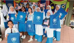  ??  ?? SMK Alam Megah, Shah Alam Form One students wave the Jalur Gemilang made from templates printed in The Star during the Raise The Flag event at the school. — Picture courtesy of Proton