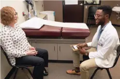  ?? UNIVERSITY OF OKLAHOMA ?? Baffour Kyerematen, a medical student at the University of Oklahoma, interacts with an LGBTQ patient volunteer as part of a simulated clinical visit.