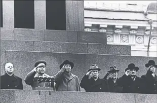  ?? AP Photo ?? Communist officials salute as a parade passes below them in Red Square in Moscow on Nov. 7, 1957. The group includes China’s Mao Zedong, third from left, and Soviet leader Nikita Khrushchev, standing to the right of Mao.