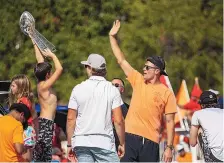  ?? DIRK SHADD/TAMPA BAY TIMES VIA ASSOCIATED PRESS ?? Tampa Bay quarterbac­k Tom Brady, right, waves as an unidentifi­ed boy holds the Lombardi Trophy as they and others celebrate their Super Bowl 55 victory with a boat parade in Tampa, Fla., Wednesday.