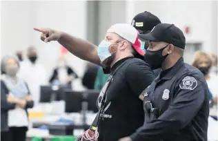  ?? PHOTO: REUTERS ?? Just leaving . . . Detroit police escort a poll challenger out after he refused to leave, due to room capacity, at the TCF Centre in Detroit, Michigan, yesterday.