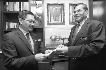  ??  ?? Othman (right) receiving the resignatio­n notice from Yusof at his office at Kompleks Seri Negeri. — Bernama photo