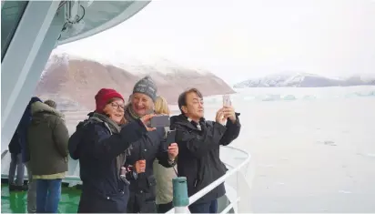  ?? (Gwladys Fouche/Reuters) ?? VISITORS TAKE pictures of a glacier in the Kongsfjord­en fjord from onboard the ‘Polarsysse­l’, the ship of the Governor of Svalbard, in the Arctic archipelag­o of Svalbard, Norway, last month.