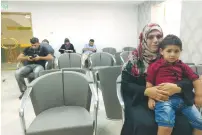  ??  ?? FATHIYA SAFADI sits in the waiting room of the Razan fertility clinic in Nablus with her son Amir, who was conceived with seminal fluid smuggled out of an Israeli prison from her husband, Ashraf.