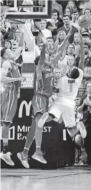  ?? [PHOTO BY SARAH PHIPPS, THE OKLAHOMAN] ?? Oklahoma State’s Jawun Evans, right, is fouled by Oklahoma’s Rashard Odomes, center, while making a go-ahead basket in the final moments of Bedlam on Saturday night in Gallagher-Iba Arena.