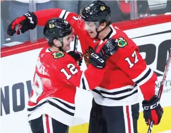  ?? AP ?? The Hawks’ Alex DeBrincat (left) and Dylan Strome celebrate DeBrincat’s goal in the first period Thursday.