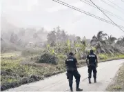  ?? SAMUEL/AP ORVIL ?? Police on Monday patrol a road to stop people from getting close to the active La Soufriere volcano.