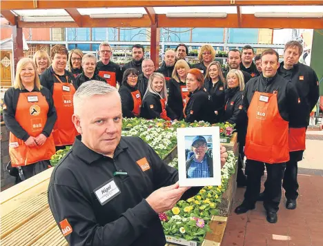  ??  ?? Nigel Inglis and staff from B&Q Dundee with a picture of Wayne Mitchell, who worked in the garden centre.