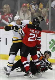  ?? Associated Press ?? Official Francis Charron gets the worst of this scrum Tuesday night between Jack Johnson and New Jersey’s Kyle Palmieri.