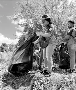  ?? ?? Youth attached to the Central Jamaica Seventh-day Adventists clean a street in the Clarendon capital of May Pen on March 17, under the Operation Save a Youth initiative.