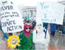  ?? — AFP ?? Beth Phuxster, left, of Denver, Colorado, dressed as Mother Nature, and Allison Otto, right, as yeti, hold signs while participat­ing in the People’s Climate March during a spring snow storm in Denver, Colorado, on Saturday.