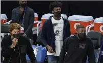  ??  ?? Injured Warriors’ Kelly Oubre Jr., bottom left, James Wiseman, middle, and Eric Paschall watch during the second half of Monday’s game against the Nuggets in San Francisco.