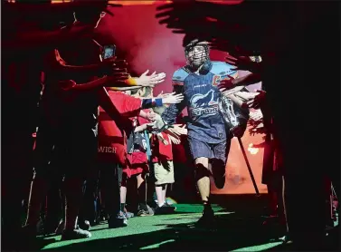  ?? SARAH GORDON/ DAY FILE PHOTO ?? New England Black Wolves captain Shawn Evans high-fives fans as he runs onto the field before a game last season at Mohegan Sun Arena. The Black Wolves, with a revamped defense, open the 2017-18 season tonight at home against the Georgia Swarm.