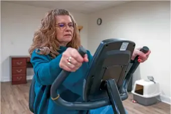  ?? AP PHOTO/AMANDA ANDRADE-RHOADES ?? Donna Cooper uses her exercise bike March 1 at her home in Front Royal, Va.