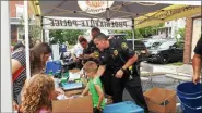  ?? BARRY TAGLIEBER — MEDIANEWS GROUP ?? Phoenixvil­le Police Cpl. Lance Frost helps hand out goodies to children at National Night Out in 2018.