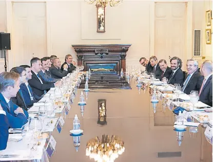  ?? Télam ?? El Presidente, junto a Guzmán y Cafiero, en la reunión con los ejecutivos rusos