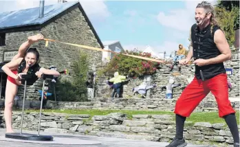  ?? PHOTO: TRACEY ROXBURGH ?? Just warming up . . . MulletMan and his partner, Mim, of Christchur­ch, entertain the crowd during the opening of the 36th Arrowtown Autumn Festival yesterday.