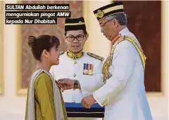  ??  ?? SULTAN Abdullah berkenan mengurniak­an pingat AMW kepada Nur Dhabitah.