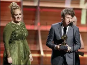  ?? THE ASSOCIATED PRESS ?? Greg Kurstin, right, and Adele accept the award for song of the year for “Hello” at the 59th annual Grammy Awards on Sunday in Los Angeles.