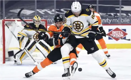  ?? Ap FiLE ?? BACK AT IT: Bruins defenseman Kevan Miller and Flyers forward Travis Konecny battle for the puck during the third period Tuesday in Philadelph­ia.