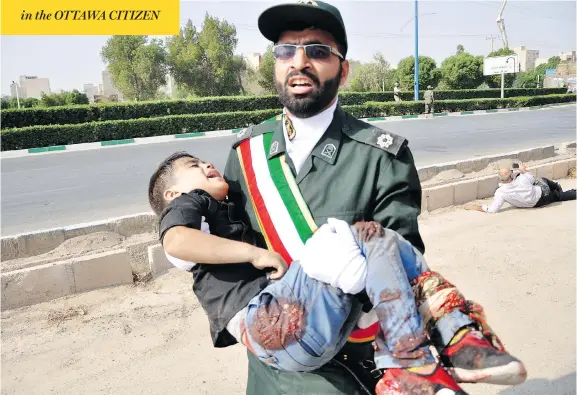  ?? BEHRAD GHASEMI / ISNA VIA THE ASSOCIATED PRESS ?? In the southweste­rn city of Ahvaz, Iran, a Revolution­ary Guard member carries a wounded boy Saturday after a shooting during a military parade marking the 38th anniversar­y of Iraq’s 1980 invasion of Iran. Gunmen attacked the military parade, killing at least eight members of the elite Revolution­ary Guard and wounding 20 others, state media said.