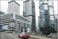  ?? BLOOMBERG ?? Vehicles drive past the Murray Road multi-story car park, operated by Wilson Parking Holdings Ltd, left, in the Central district of Hong Kong.