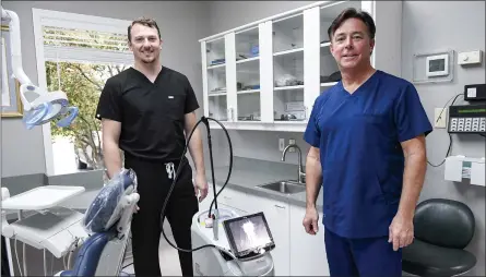  ?? BEN HASTY — READING EAGLE ?? Dr. Jon Angstadt and Dr. Eric R. Angstadt stand next to the Waterlase laser at Angstadt Family Dental in Wyomissing.