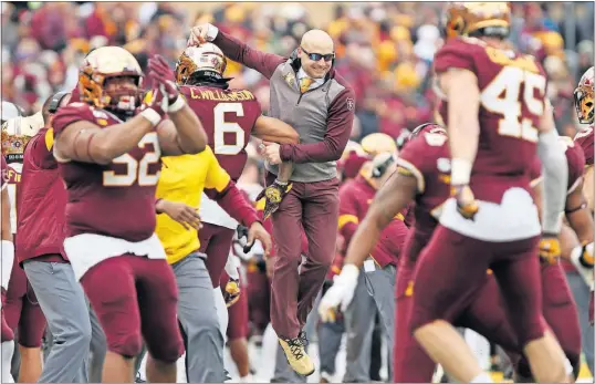  ?? [STACY BENGS/THE ASSOCIATED PRESS] ?? Minnesota head coach P.J. Fleck, center, jumps in celebratio­n with defensive back Chris Williamson during the win over Penn State.