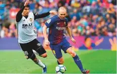  ?? AFP ?? Valencia’s Carlos Soler (left) vies with Barcelona’s Andres Iniesta. Iniesta has signed a ‘lifetime contract’ with Barcelona.