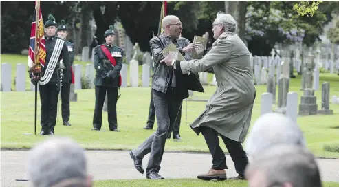  ?? BRIAN LAWLESS / THE ASSOCIATED PRESS ?? Canadian Ambassador to Ireland Kevin Vickers, right, wrestles with a protester at Grangegorm­an Military Cemetery in Dublin last week during a state ceremony to remember the British soldiers who died during the Easter Rising.