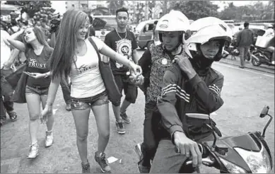  ??  ?? Women hand out free condoms to people in Manila. (Photo: afp)