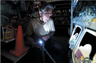  ?? DOUG DURAN — STAFF PHOTOGRAPH­ER ?? Joe Gerard, of Santa Rosa, uses a flashlight to light his way as he purchases enough chain to secure his home generator at True Value Hardware in Santa Rosa on Wednesday. The city is in an area where PG&E shut off power to reduce wildfire risk.