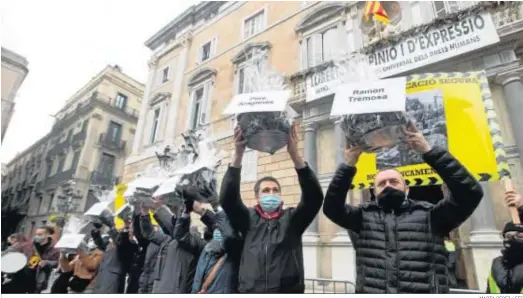  ?? MARTA PÉREZ / EFE ?? Comerciant­es sostienen el carbón que regalaron ayer a todos los consellers ante el Palau de la Generalita­t en protesta por las medidas anti Covid-19.