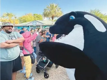  ?? DEWAYNE BEVIL/ORLANDO SENTINEL PHOTOS Below: Jon Peterson, park ?? Above: A costumed Shamu character interacts with SeaWorld Orlando visitors on Thursday. president, explains changes to Orca Stadium.