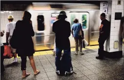  ?? Spencer Platt / TNS ?? People wait for a Metropolit­an Transporta­tion Authority (MTA) subway to arrive in New York City.