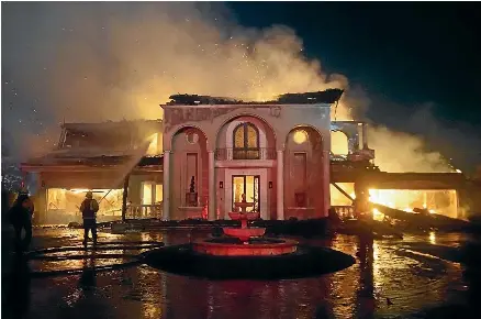  ?? AP ?? Firefighte­rs spray water on a gutted house during the wildfire that swept through Laguna Niguel, California, this week. Drought and warmer weather caused by climate change is worsening the wildfire danger in the western US.