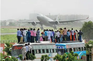  ?? — PTI ?? People look on as a flight with Haj pilgrims take off in Jaipur on Thursday.