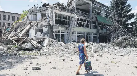  ?? EUROPA PRESS ?? Una mujer pasa por delante de los restos de la panadería destruida en Lisichansk (Lugansk).